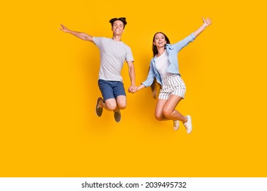 Full length body size view of attractive cheerful couple jumping having fun rest isolated over bright yellow color background - Shutterstock ID 2039495732