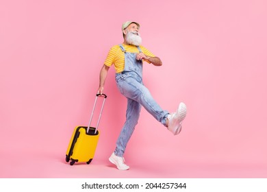 Full length body size view of attractive cheerful funny content man carrying bag going isolated over pink pastel color background