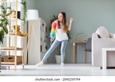 Full length body size view of attractive cheerful crazy overjoyed girl dancing with fluffy brush having fun vacation at home indoors