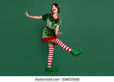 Full length body size view of attractive cheerful girl wearing elf look dancing isolated over green color background