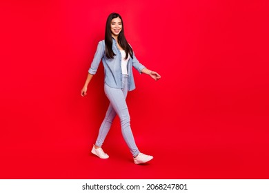 Full length body size view of attractive cheerful girl walking isolated over bright red color background - Powered by Shutterstock