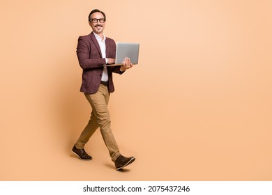 Full length body size view of attractive cheerful skilled man going using laptop copy empty space isolated over beige color background - Shutterstock ID 2075437246