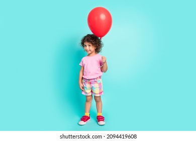 Full length body size view of attractive cheerful girl holding air ball isolated over bright teal turquoise color background