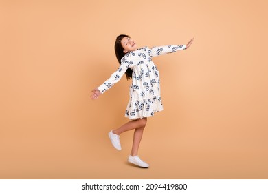 Full length body size view of attractive cheery girl jumping dancing good mood isolated on beige pastel color background
