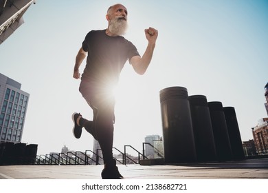 Full Length Body Size View Of Attractive Elderly Retired Sportive Grey-haired Man Running Fast Move On Building Outdoors.