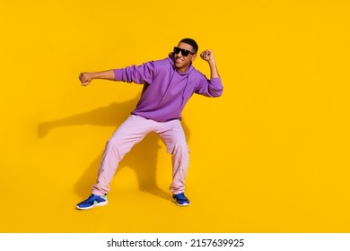 Full length body size view of attractive cheerful cool guy having fun dancing clubbing isolated over bright yellow color background - Powered by Shutterstock