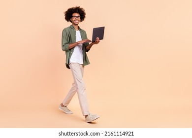 Full Length Body Size View Of Attractive Cheerful Trendy Guy Going Using Laptop Startup Isolated Over Beige Pastel Color Background