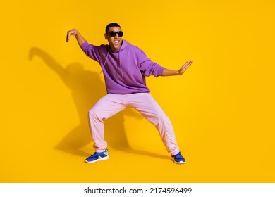 Full length body size view of attractive cheerful guy fooling dancing clubbing isolated over bright yellow color background