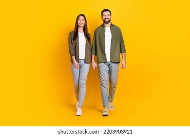 Full length body size view of attractive cheerful couple holding hands going isolated over bright yellow color background - Powered by Shutterstock