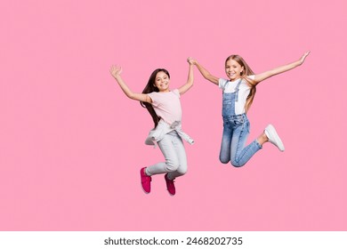 Full length body size view of two people nice cute lovely attractive cheerful cheery careless straight-haired pre-teen girls having fun great day isolated over blue pastel background - Powered by Shutterstock