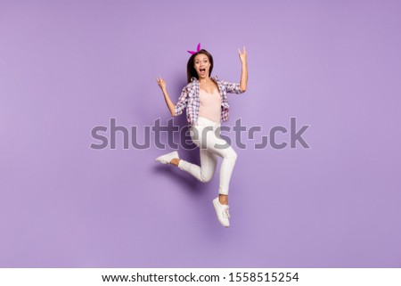 Full length body size view of her she nice attractive cheerful cheery funky overjoyed girl jumping having fun showing horns sign isolated on violet purple lilac pastel color background