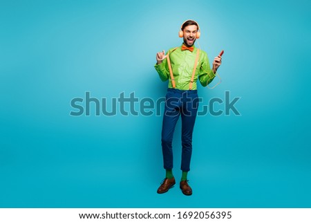 Full length body size view of his he nice attractive glad positive cheerful cheery guy listening music having fun isolated on bright vivid shine vibrant blue green teal turquoise color background