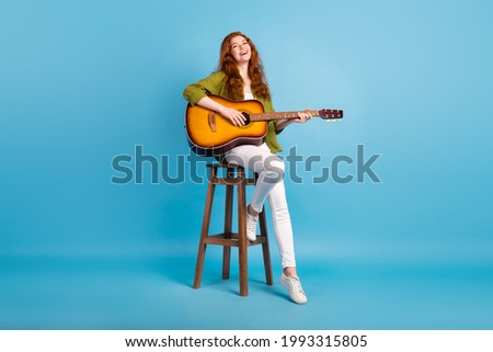 Full length body size view of pretty cheerful girl playing guitar singing hit isolated over pastel blue color background