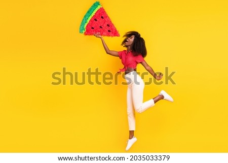 Full length body size view of attractive cheerful funny girl jumping biting fake big watermelon isolated over bright yellow color background