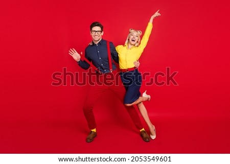 Full length body size view of trendy cheerful ecstatic funky couple dancing having fun isolated over bright red color background