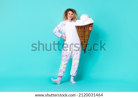 Full length body size view of attractive cheerful wavy-haired girl holding gelato isolated on bright teal turquoise color background
