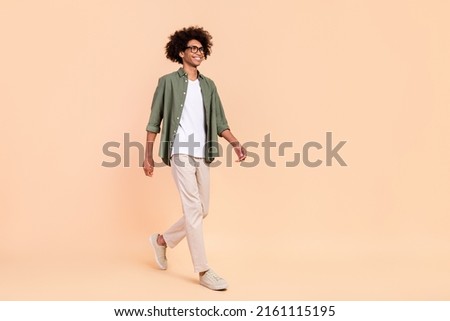 Full length body size view of attractive cheerful smart guy going isolated over beige pastel color background Stock photo © 