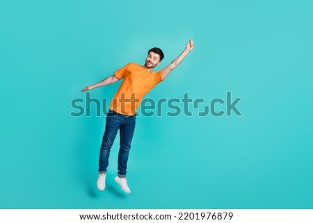 Full length body size view of sporty active energetic man jumping hanging empty blank space isolated on cyan color background