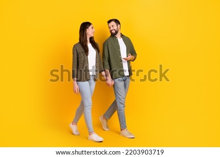 Full length body size view of attractive cheerful couple spending day talking going isolated over bright yellow color background