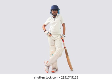 full length of a boy in cricket uniform standing with bat