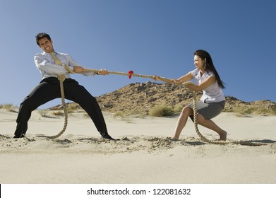 Full Length Of  Business People Playing Tug Of War In Desert