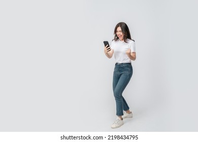 Full Length Of Cheerful Asian Woman Smiling With Using Smartphone Trading Or Promotion Shopping Online On Isolated White Background. Successful Young Female Trading In Smartphone. Creative Collage.