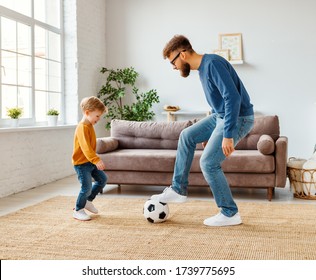 Full Length Cheerful Boy Laughing   Near Bearded Father With Ball While Playing Football At Home Together
