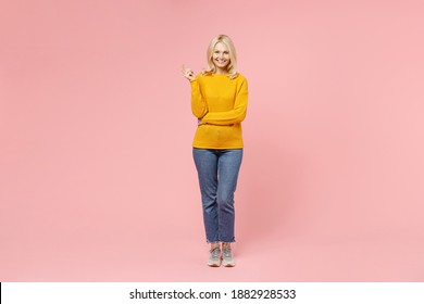 Full Length Of Cheerful Funny Elderly Gray-haired Blonde Woman Lady 40s 50s Years Old Wearing Yellow Basic Sweater Standing And Looking Camera Isolated On Pastel Pink Color Background Studio Portrait