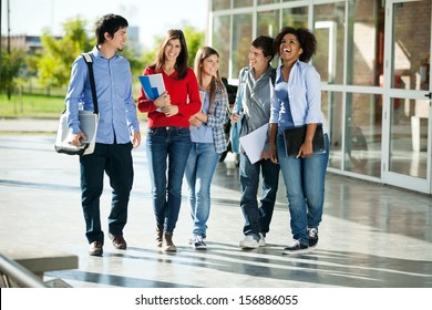 Full Length Of Cheerful University Students Walking On Campus