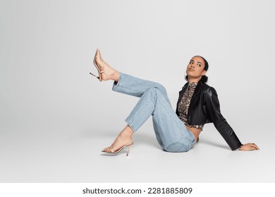 full length of confident african american woman in high heeled sandals and trendy outfit posing on grey - Powered by Shutterstock