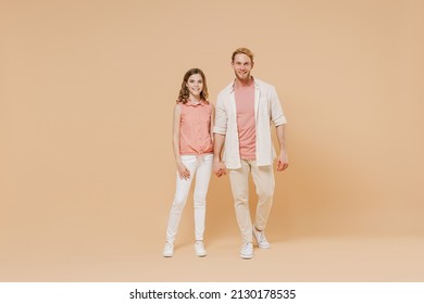 Full Length Cool Young Parent Man Have Fun With Cute Child Teen Girl In Casual Pastel Clothes. Daddy Little Kid Daughter Stand Hold Hands Isolated On Beige Background. Father's Day Love Family Concept