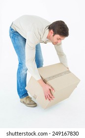 Full Length Of Courier Man Picking Up Cardboard Box On White Background