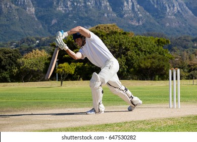 Full length of cricketer playing on field during sunny day