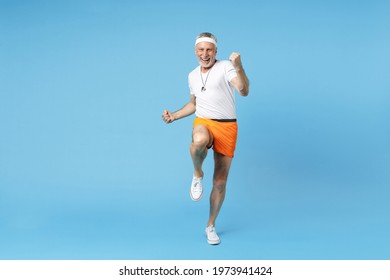 Full Length Elderly Gray-haired Sportsman Strong Trainer Instructor Man 60s In Sportswear White T-shirt Do Warm-up Squats Aerobics Exercises Isolated On Blue Background Studio Fitness Sport Concept