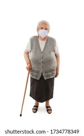 Full Length Of An Elderly Woman With A Cane Wearing A Protective Face Mask Isolated On White Background