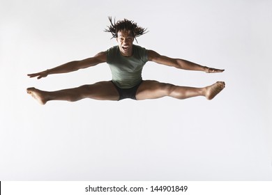 Full length of excited male ballet dancer jumping isolated on white background - Powered by Shutterstock