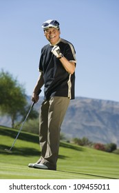 Full Length Of An Excited Middle Aged Man Playing Golf At Golf Course