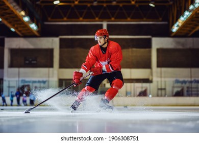 Full Length Of Fearless Hockey Player Skating Towards Goal And Trying To Make A Score. Hall Interior. Winter Sports.