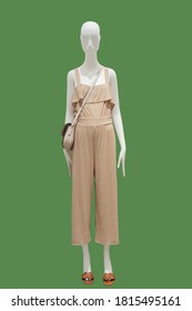 Full length female mannequin dressed in summer fashionable clothes, isolated on green background. No brand names or copyright objects.