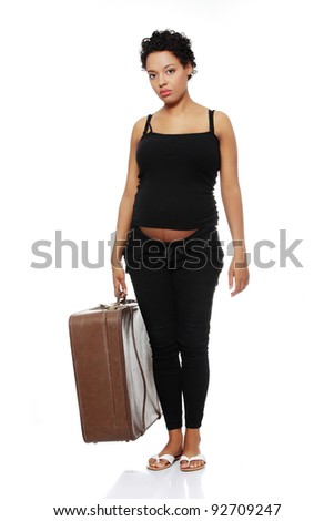 Full length front view of a sad pregnant woman holding a case.