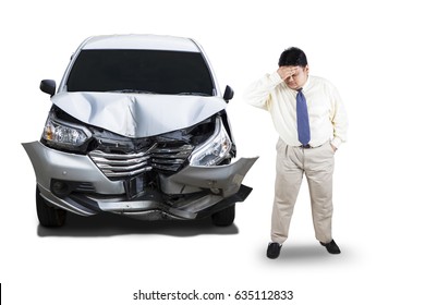 Full length of frustrated businessman standing next to a damaged car after collision, isolated on white background
