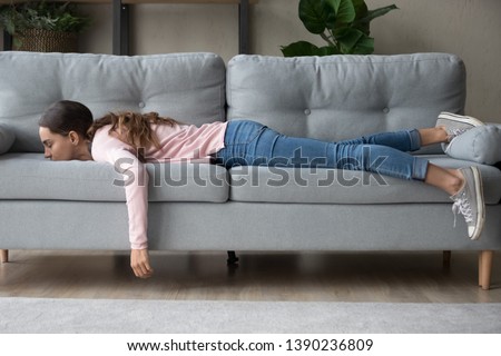 Full length of girl lying rest at home in living room buried her face in couch feels exhaustion having day nap lack of energy after party sleepless night or overworked, too tired no motivation concept Foto stock © 