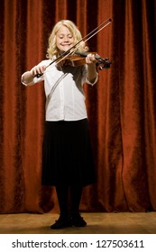 Full Length Of A Girl Playing Violin On Stage