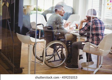 Full length of handicap businessman discussing with colleague in creative office - Powered by Shutterstock