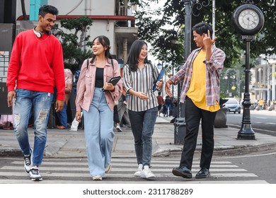 Full length of happy college students walking together crossing the street at zebra cross - Shutterstock ID 2311788289