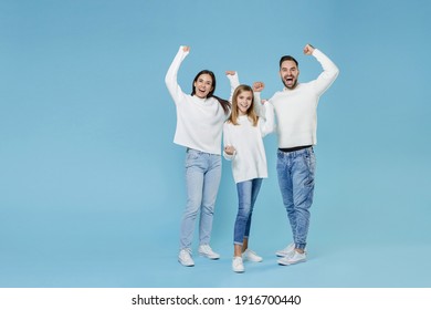 Full Length Of Happy Joyful Young Parents Mom Dad With Child Kid Daughter Teen Girl In Sweaters Clenching Fists Like Winner Isolated On Blue Background Studio Portrait. Family Day Parenthood Concept