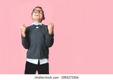 Full Length Happy Kid With Arms Up Celebrating Winning. Energetic School Boy Screaming While Flying Up. Confident Strong Winner. I Can Do It. Child Feeling Inspired Crazy And Overjoyed.