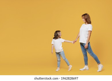 Full Length Happy Woman In Basic White T-shirt Have Fun Child Baby Girl 5-6 Years Old Hold Hands Walk Go Run Mom Little Kid Daughter Isolated On Yellow Color Background Studio Mother's Day Love Family