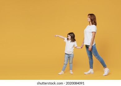 Full Length Happy Woman In Basic White T-shirt Have Fun Child Baby Girl 5-6 Years Old Hold Hands Walk Go Run Mom Little Kid Daughter Isolated On Yellow Color Background Studio Mother's Day Love Family