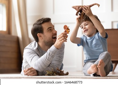 Full length happy young man dad lying on heated warm floor, playing toys with joyful small schoolboy son at home. Overjoyed two generations family enjoying weekend playtime together in living room. - Shutterstock ID 1646468773